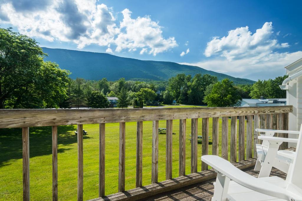 A Wooden Deck Overlooking A Lush Green Field The Equinox Golf Resort  Spa In Manchester Vt